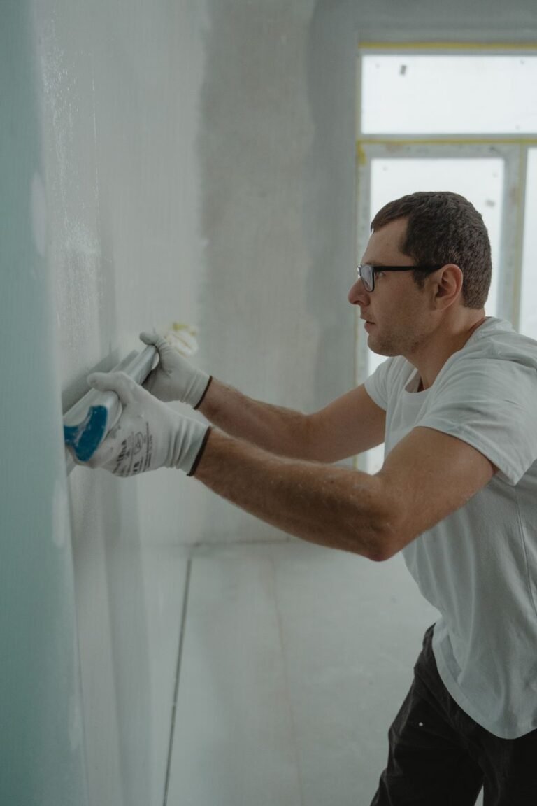 Albañil aplicando pasta en una pared durante una reforma